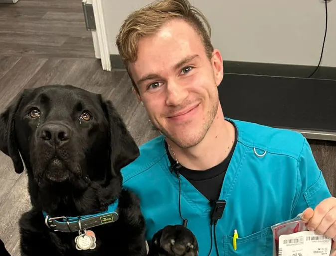 A photo of a veterinary student with a black lab